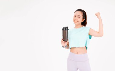 Asyalı genç, güzel ve neşeli bir kadının portresi. Elinde sallama şişesi, arka planda izole edilmiş.