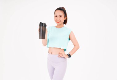 Asyalı genç, güzel ve neşeli bir kadının portresi. Elinde sallama şişesi, arka planda izole edilmiş.