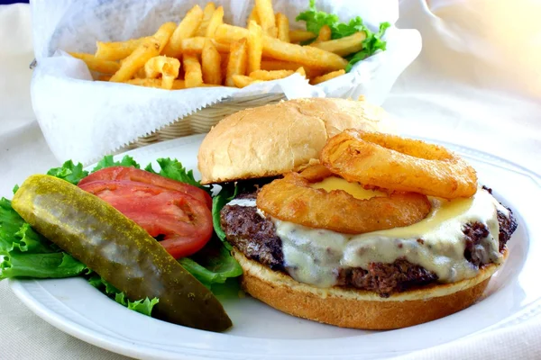Hambúrguer de queijo com batatas fritas e anéis de cebola — Fotografia de Stock