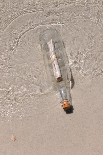 Flaschenpost am Ufer angespült — Stockfoto