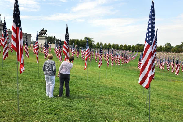 Mujeres miran el nombre de la víctima del 9-11 en la bandera de EE.UU. —  Fotos de Stock