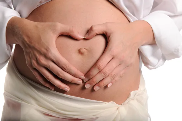 Mulher grávida fazendo forma de coração com as mãos — Fotografia de Stock