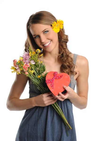 Jonge vrouw met bloemen en cadeau — Stockfoto