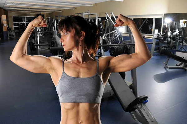 Woman Flexing at the Gym — Stok fotoğraf