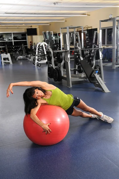 Kadın fitness topu kullanarak germe — Stok fotoğraf