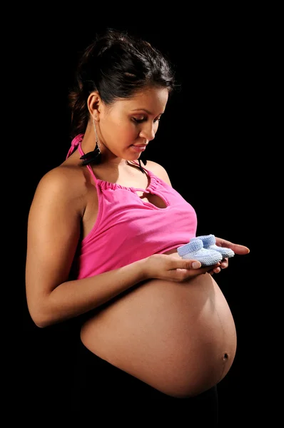 Hispanic zwangere vrouw met baby schoenen — Stockfoto