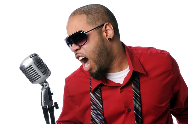 Молодой человек поет в винтажный микрофон — стоковое фото