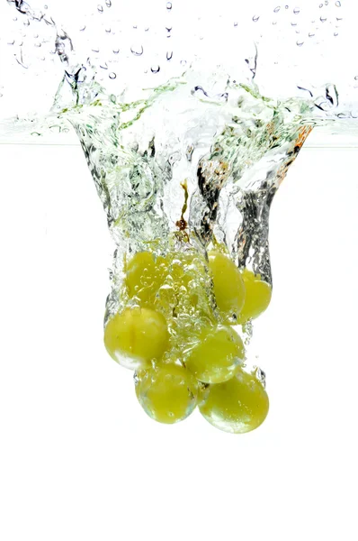 Green Grapes Splashing into Water — стоковое фото