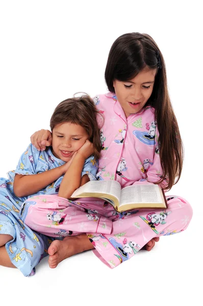 Chica leyendo cuentos para dormir a la hermana —  Fotos de Stock