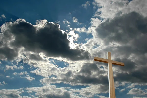 Kreuz gegen helle Wolken — Stockfoto