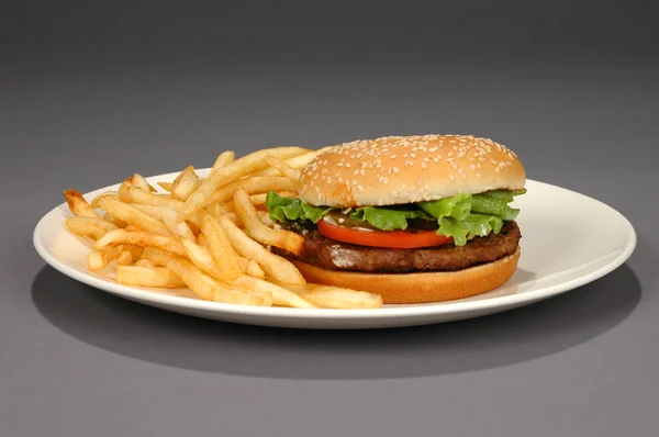 Hambúrguer e batatas fritas em fundo neutro — Fotografia de Stock