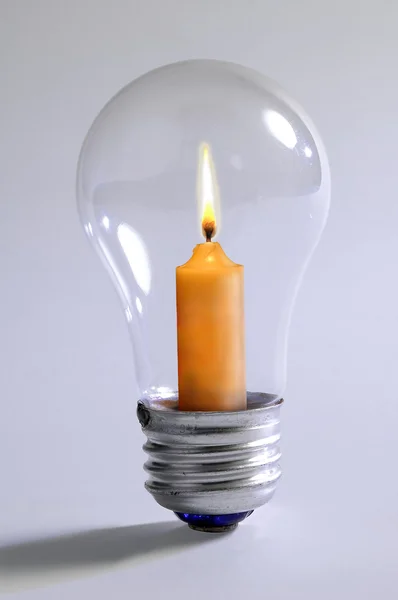Лампочка и свеча — стоковое фото