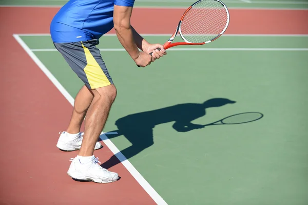 Tennispelaaja ja Shadow kentällä — kuvapankkivalokuva