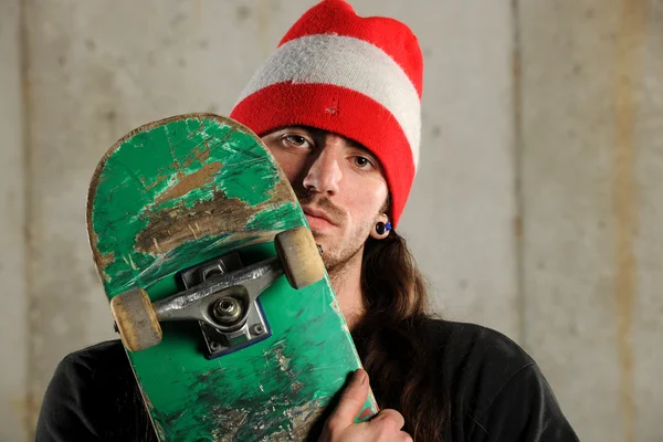 Mladý muž držení skateboardu — Stock fotografie