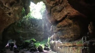 Güneş ışığı mağaranın HD videosuna giriyor. Mağara odasına bir ışık huzmesi girdi. Mağaranın güzelliğinin görüntüsü.