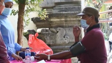 Asyalı kadın doktor hemşire hastaya Covid-19 aşısı yapıyor, Denpasar, Bali, Endonezya, 21 Ekim 2021