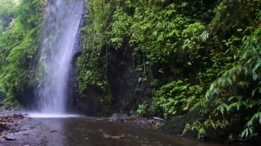 Kayalık bir uçurumdan düşen bir şelalenin görüntüleri, Tukad cepung.