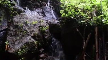 Kayalık bir uçurumdan düşen bir şelalenin görüntüleri, Tukad cepung.