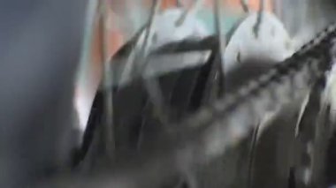 Dönen motosiklet tekerlekleri, vites ve zincirin dönüşü, motorlu aracın motorunun video dönüşü.