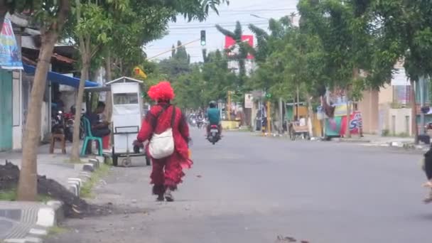 Clown Camicia Rossa Allontana Cercare Sostentamento Incrocio Luci Rosse Sulla — Video Stock