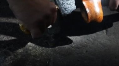 Keris gemisi. Bir adam bir Kris 'i konteynırından çıkarır. Keris adında geleneksel bir Cava silahı. Karanlık bir yerde Java keris