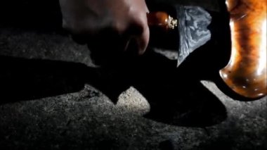 Keris gemisi. Bir adam bir Kris 'i konteynırından çıkarır. Keris adında geleneksel bir Cava silahı. Karanlık bir yerde Java keris
