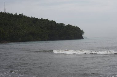 Sabah görüşü Air Manis sahilinde, West Sumatra bulutlu gökyüzü. Air Manis Sahili, Malin Kundang efsanesiyle yakından ilişkilidir.