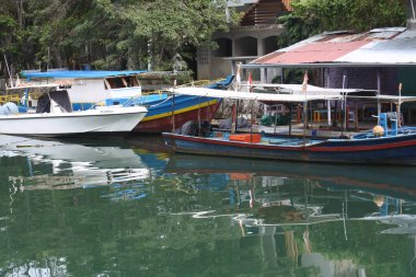 View of the river and boats and the activities of residents near the Siti Nurbaya Padang bridge, West Sumatra, Indonesia, Indonesia - May 21th 2022.