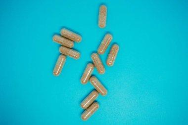 Mavi arka planda kahverengi kapsüller. İlaç ve kendi kendini tedavi. Tedavi için ilaç seti