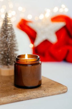 Noel süslemelerinin arka planında soya kokulu mum yakmak