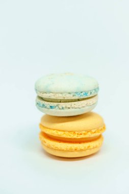 Beyaz arka planda sarı ve mavi makaronlar. Taze lezzetli tatlı. Çay ya da kahve için tatlı