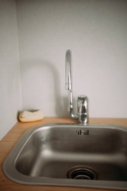 Mutfak metal musluğu lavabonun üstünde. Mutfak aletleri