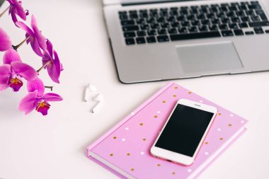 Orkide çiçeği, not defteri ve dizüstü bilgisayar. Çalışmak ve dinlenmek için rahat bir yer.