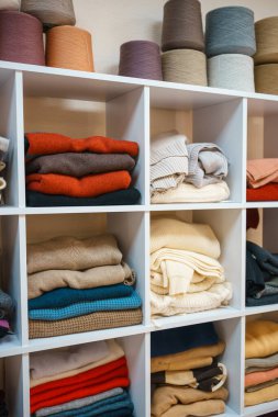 Beyaz raflarda farklı renklerde örülmüş bir sürü şey var. Yüksek kalite fotoğraf
