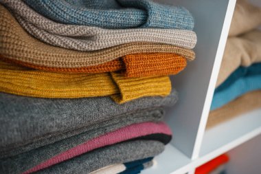 Beyaz raflarda farklı renklerde örülmüş bir sürü şey var. Yüksek kalite fotoğraf