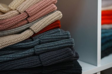 Beyaz raflarda farklı renklerde örülmüş bir sürü şey var. Yüksek kalite fotoğraf