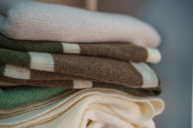 Beyaz raflarda farklı renklerde örülmüş bir sürü şey var. Yüksek kalite fotoğraf