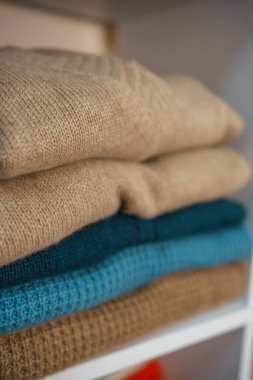 Beyaz raflarda farklı renklerde örülmüş bir sürü şey var. Yüksek kalite fotoğraf