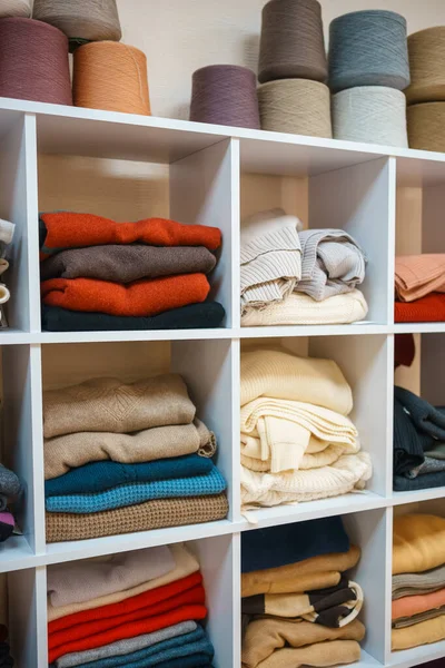Beyaz raflarda farklı renklerde örülmüş bir sürü şey var. Yüksek kalite fotoğraf