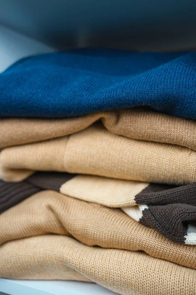 Beyaz raflarda farklı renklerde örülmüş bir sürü şey var. Yüksek kalite fotoğraf