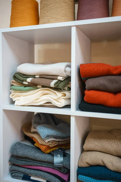 Beyaz raflarda farklı renklerde örülmüş bir sürü şey var. Yüksek kalite fotoğraf