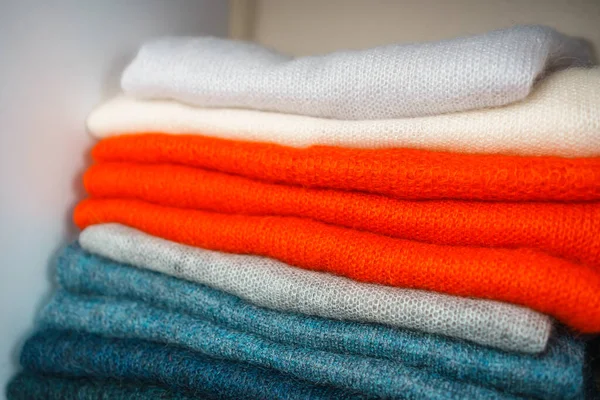 Beyaz raflarda farklı renklerde örülmüş bir sürü şey var. Yüksek kalite fotoğraf