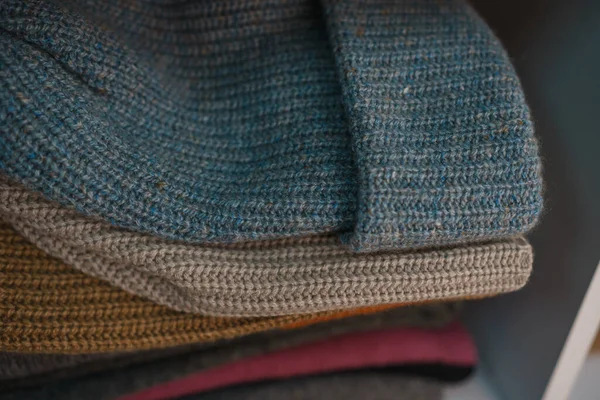 Beyaz raflarda farklı renklerde örülmüş bir sürü şey var. Yüksek kalite fotoğraf