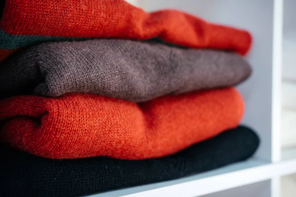 Beyaz raflarda farklı renklerde örülmüş bir sürü şey var. Yüksek kalite fotoğraf