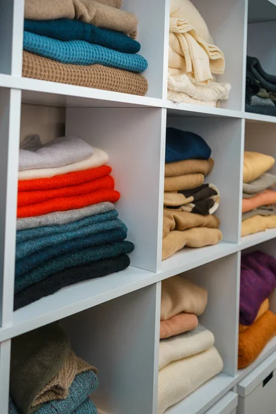 Beyaz raflarda farklı renklerde örülmüş bir sürü şey var. Yüksek kalite fotoğraf