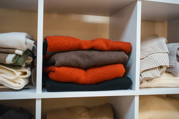 Beyaz raflarda farklı renklerde örülmüş bir sürü şey var. Yüksek kalite fotoğraf