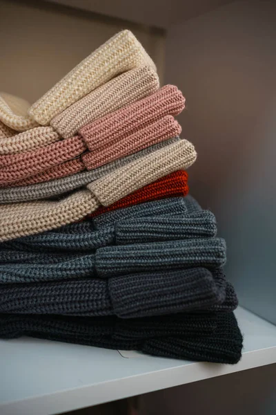 Beyaz raflarda farklı renklerde örülmüş bir sürü şey var. Yüksek kalite fotoğraf