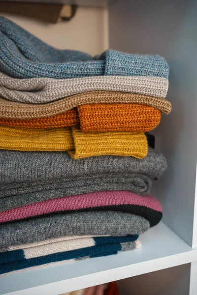 Beyaz raflarda farklı renklerde örülmüş bir sürü şey var. Yüksek kalite fotoğraf