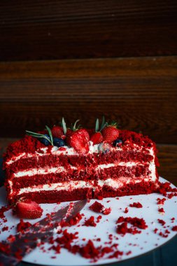 Tahtada kırmızı kadife kek. Bir dilim kek. Ahududulu kek. Şeytanların keki. Düğün tatlısı. Doğum günü partisi. Lezzetli tatlı. Geleneksel Amerikan tatlıları. Yüksek kalite fotoğraf