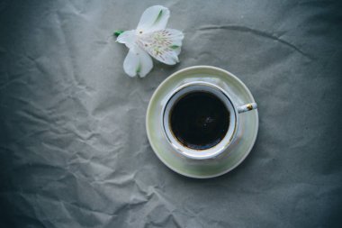 cup of coffee and white flower on gray background. top view . High quality photo